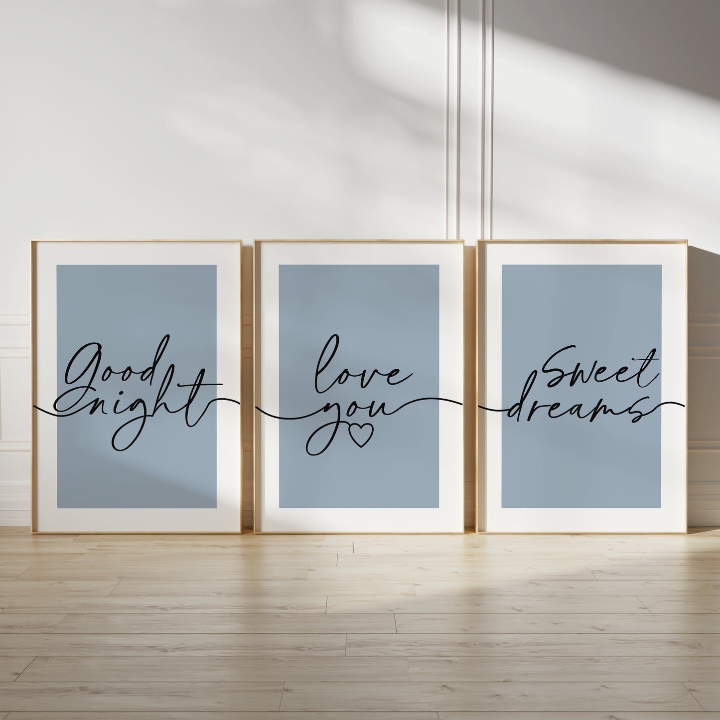 Three unframed wall art prints with light blue backgrounds and black cursive text reading 'Good night,' 'love you,' and 'Sweet dreams,'