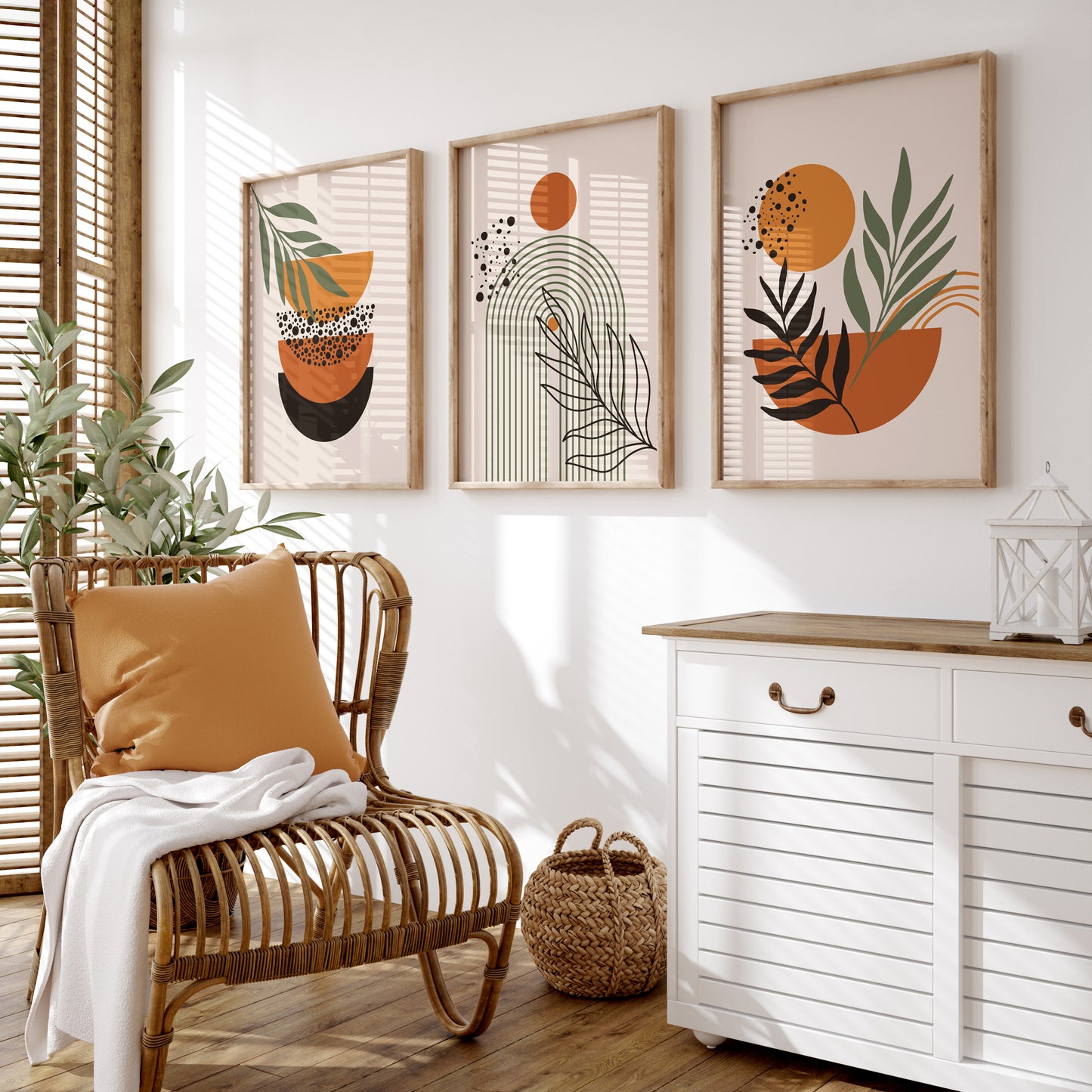 Boho wall art trio, all featuring abstract shapes in orange, terracotta and black with green leaves, on cream backgrounds