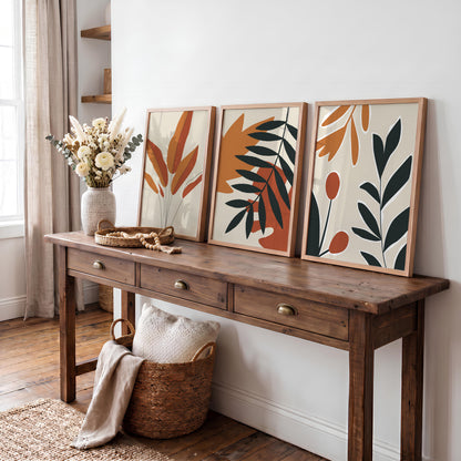 Autumn wall art set of three unframed prints with leaves in shades of orange, terracotta and black