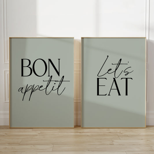 Two unframed vertical kitchen wall art prints in sage green. The left print says “BON appetit” in black lettering on a pale sage green background, and the right print says “Let’s EAT” in black lettering on the same pale sage green background.
