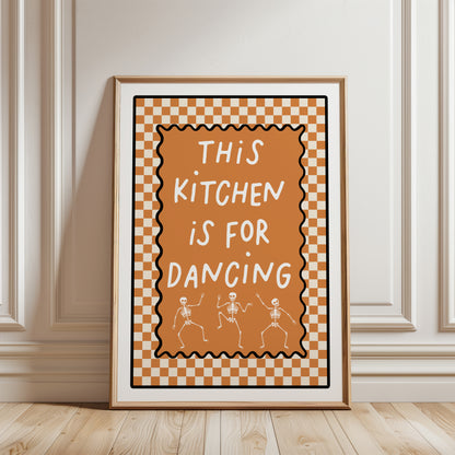 halloween kitchen wall art print with funny quote THIS KITCHEN IS FOR DANCING with skeleton illustrations on a orange chequered background