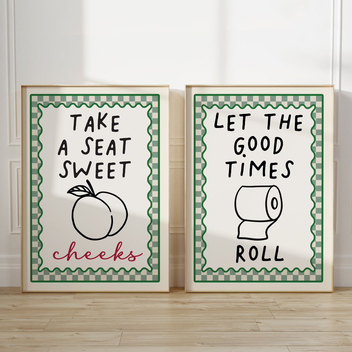set of 2 sage green bathroom wall art prints each with chequered borders and funny quotes, print one reads "take a seat sweet cheeks" print 2 reads "Let the good times roll"