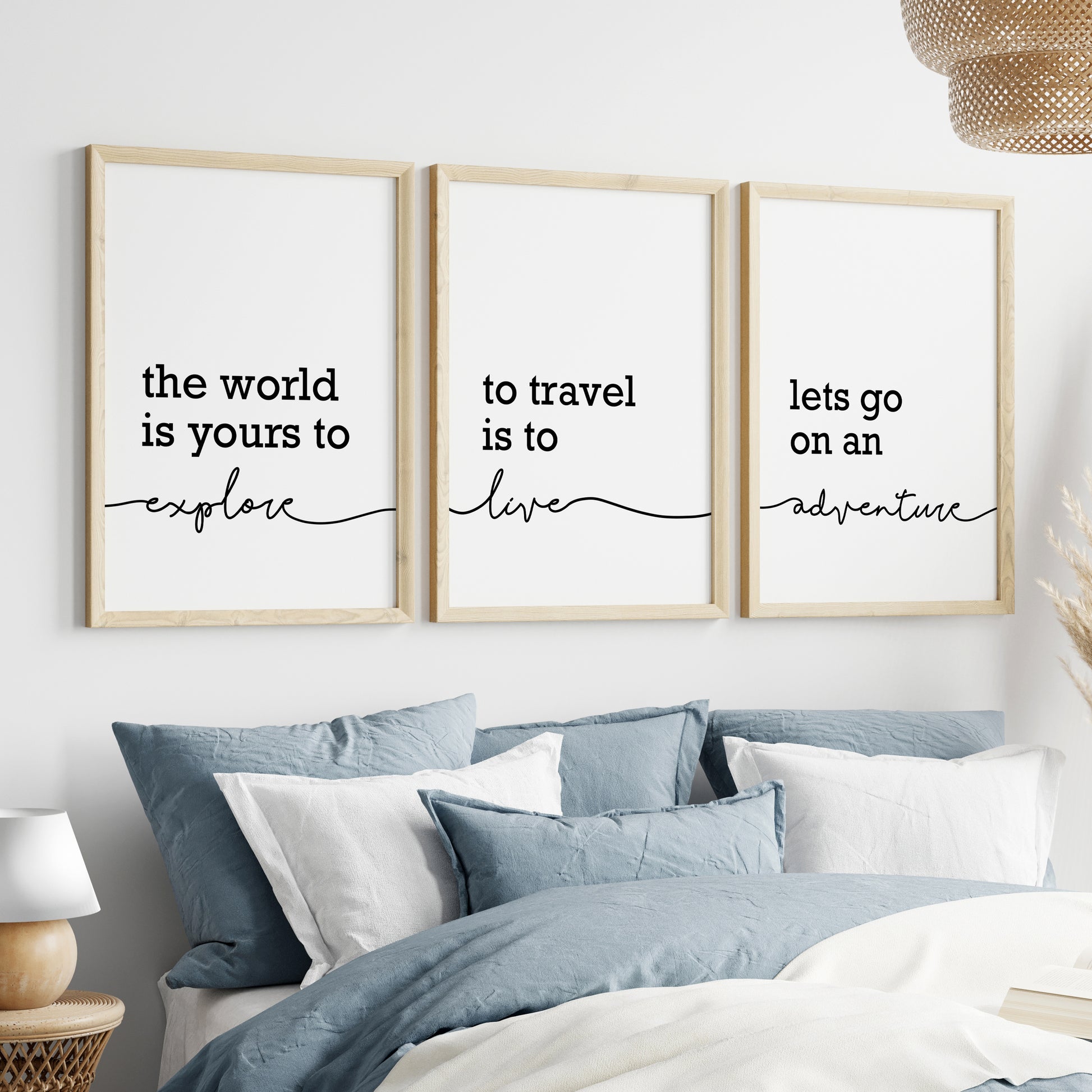 Three unframed wall art prints with black script text on a white background. The prints read: 'the world is yours to explore', 'to travel is to live', and 'lets go on an adventure'.